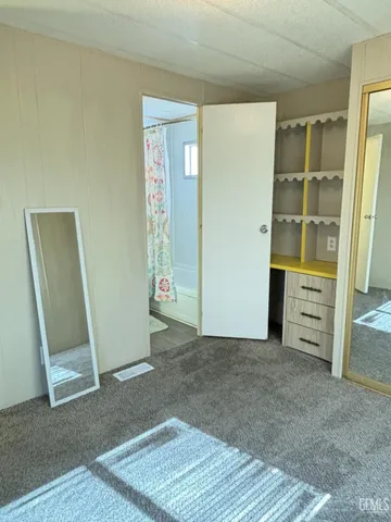 an empty room with closet and mirror