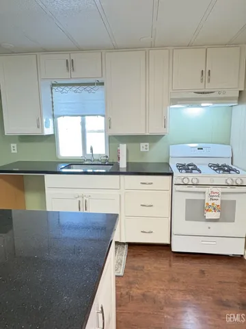 a kitchen with granite countertop a stove a sink and a granite counter tops