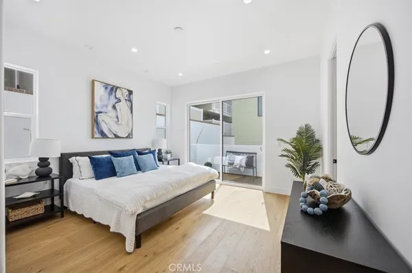a bedroom with a bed a mirror and potted plant