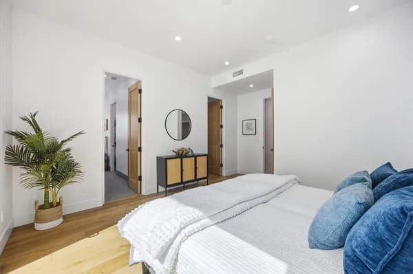a bedroom with a bed and wooden floor