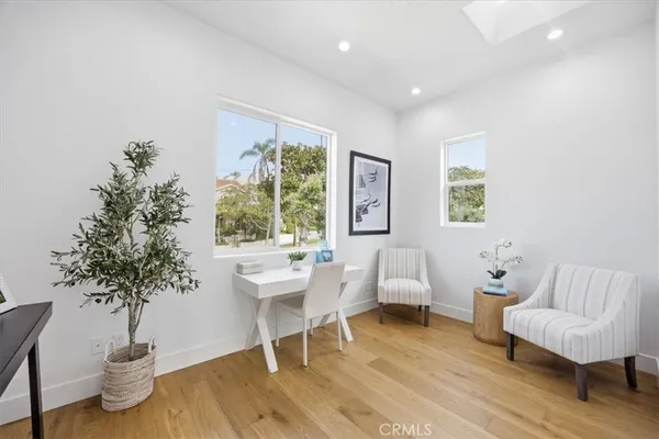 a living room with furniture a potted plant and a large window