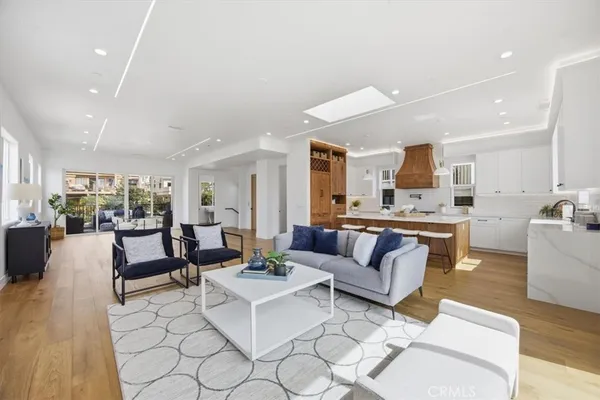 a living room with furniture kitchen view and a large window
