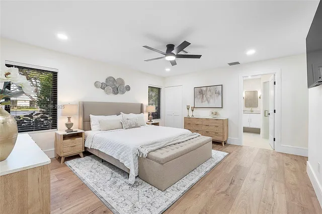 a spacious bedroom with a large bed and a chandelier