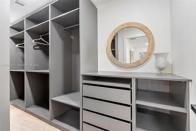 a view of a livingroom with wooden floor and a mirror
