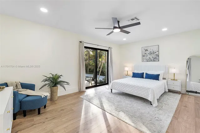 a bedroom with a large bed and a potted plant