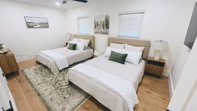 a bedroom with two beds and painting on the wall