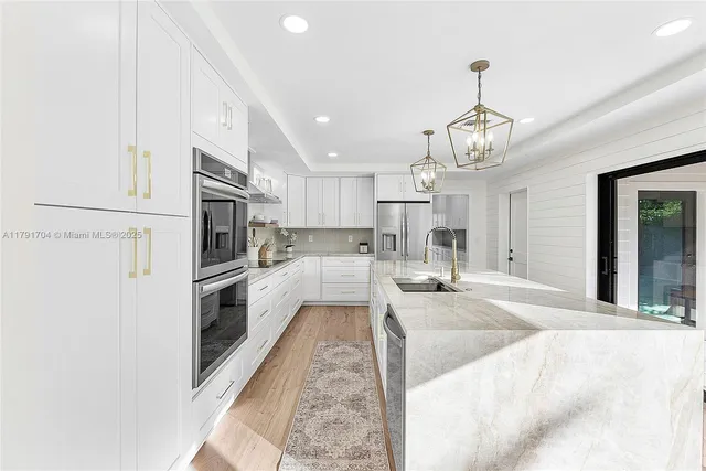 a large white kitchen with refrigerator stove and oven