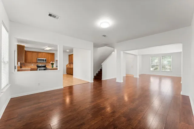 a view of a livingroom with wooden floor and a hallway