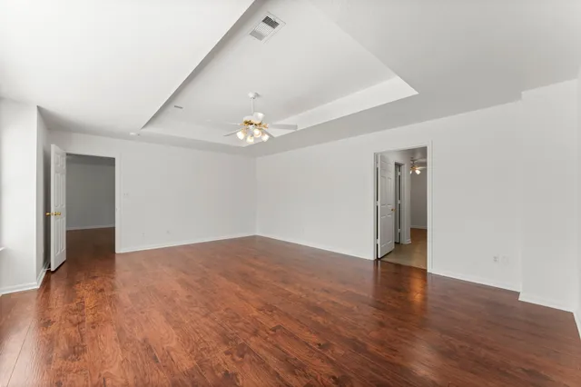 a view of an empty room with wooden floor