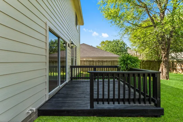 a view of backyard with deck and outdoor seating