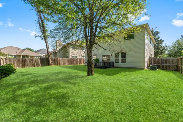 a view of a house with backyard and a tree