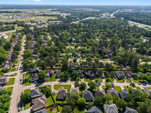 an aerial view of residential houses with outdoor space and trees