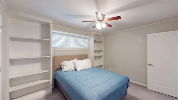 a bedroom with a bed and a ceiling fan
