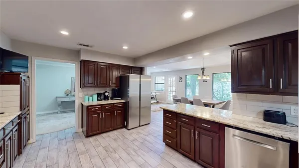 a kitchen with stainless steel appliances granite countertop a sink stove and refrigerator