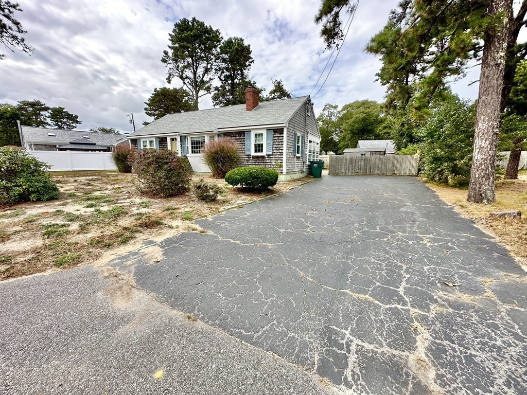 101 Swan River Road Dennis, MA 02670 - Photo 3 of 19 a front view of a house with a yard and garage