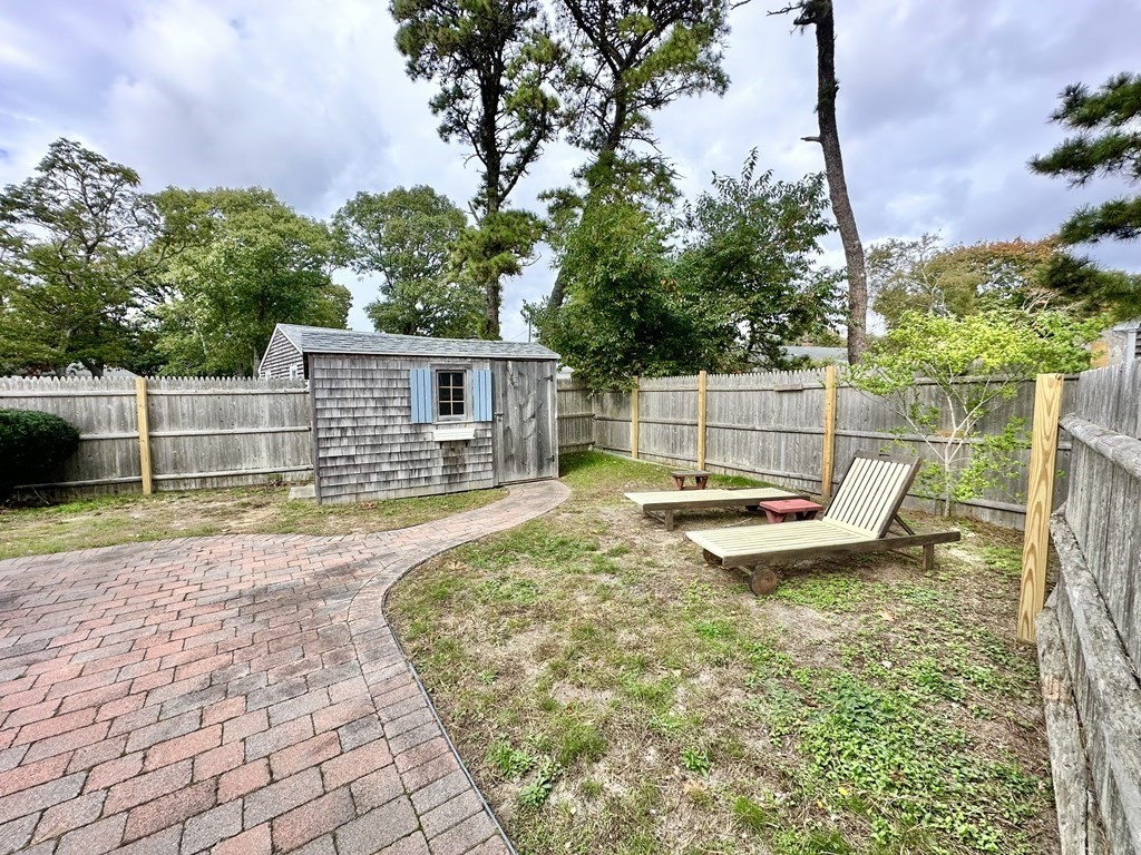 101 Swan River Road Dennis, MA 02670 - Photo 5 of 19 a view of a backyard with a bench and plants