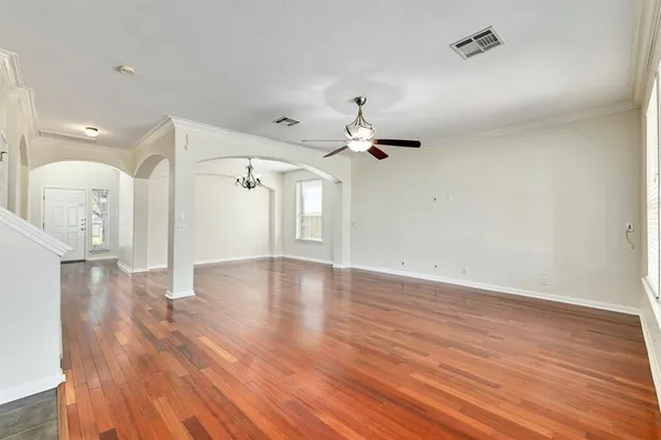a view of a livingroom with wooden floor and a ceiling fan