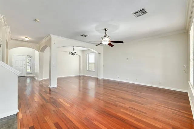 a view of a livingroom with wooden floor and a ceiling fan