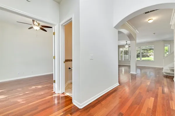 a view of a big room with wooden floor and windows