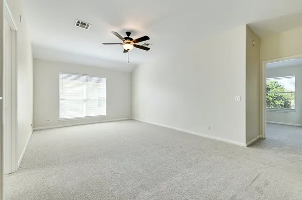 a view of empty room with ceiling fan