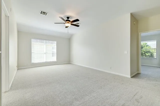 a view of empty room with ceiling fan