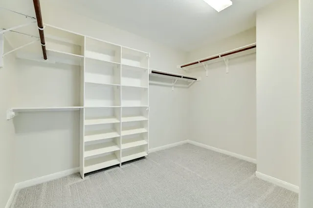 an empty room with a window and a ceiling fan