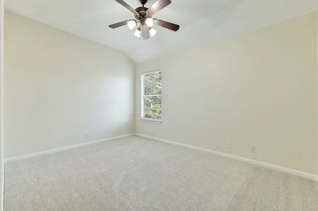 a view of a room with a window and a ceiling fan