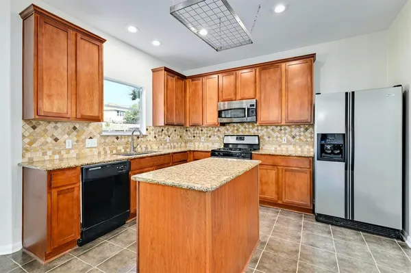 a kitchen with stainless steel appliances granite countertop refrigerator sink and cabinets