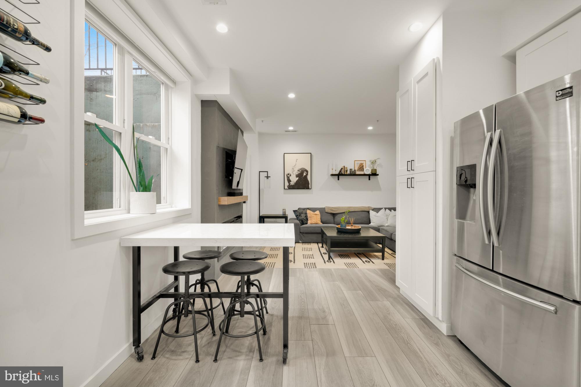 4816 3rd Street Northwest, Unit 2 Washington, DC 20011 - Photo 11 of 35 a kitchen with stainless steel appliances a refrigerator a stove a dining table and chairs with wooden floor