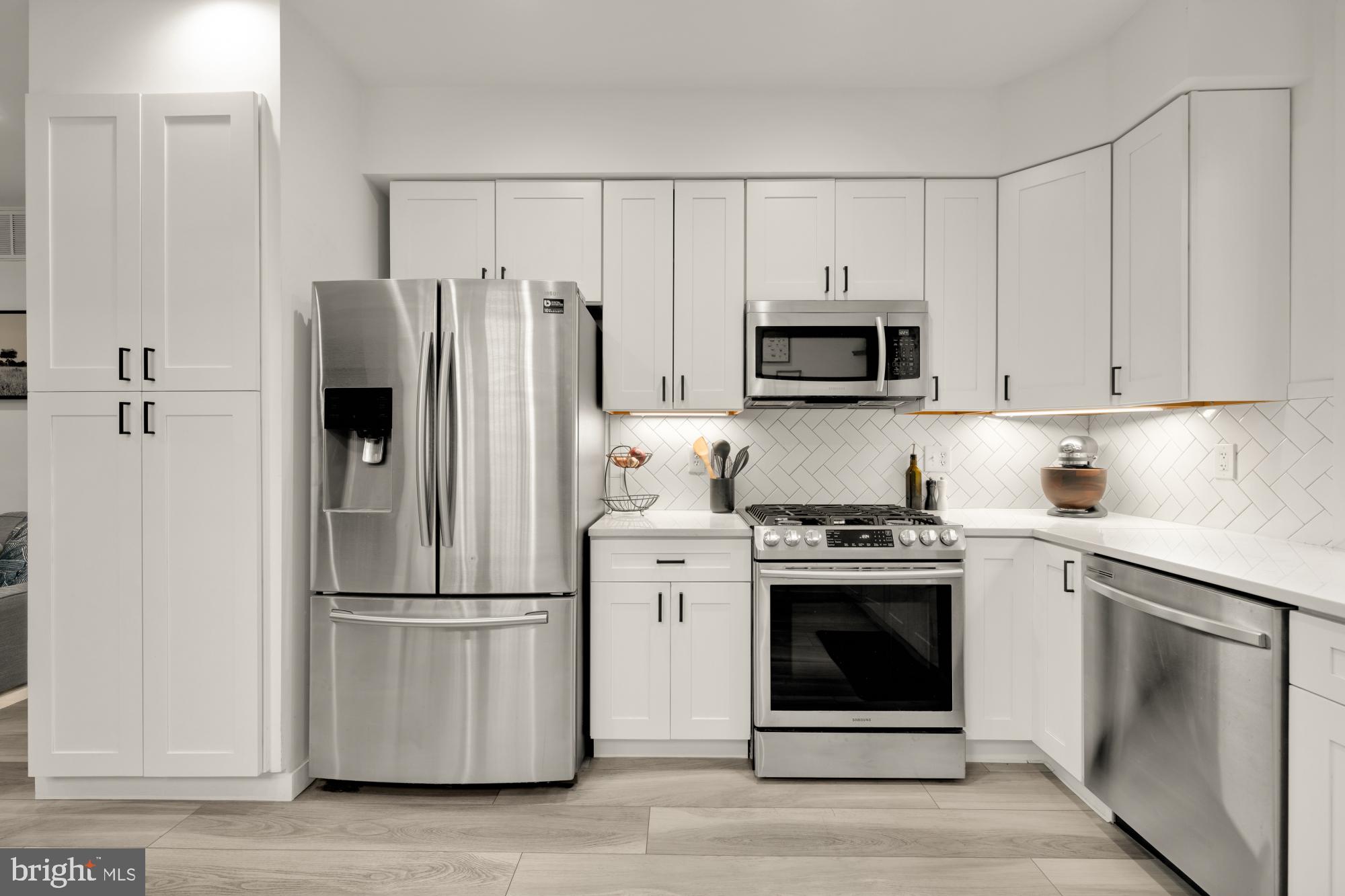4816 3rd Street Northwest, Unit 2 Washington, DC 20011 - Photo 13 of 35 a kitchen with white cabinets and stainless steel appliances
