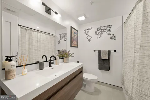 a bathroom with a sink a toilet and shower curtain