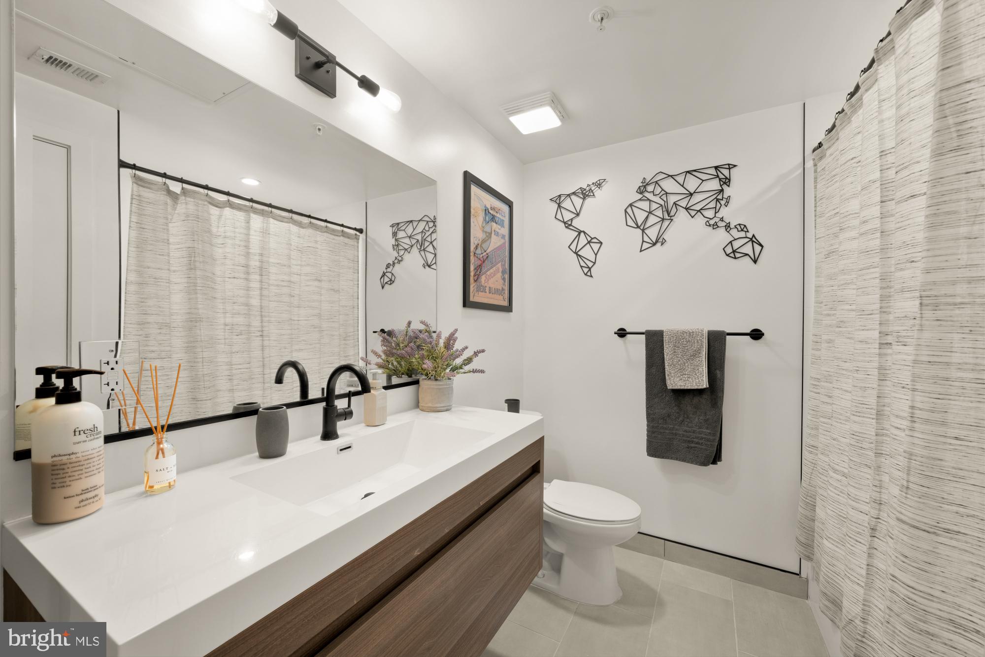 4816 3rd Street Northwest, Unit 2 Washington, DC 20011 - Photo 26 of 35 a bathroom with a sink a toilet and shower curtain