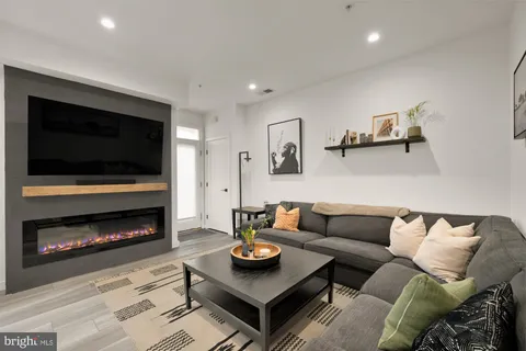 a living room with furniture a flat screen tv and a fireplace