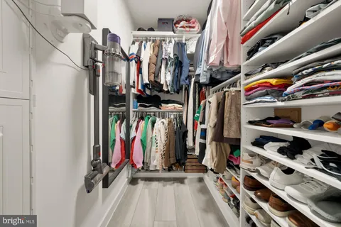 a view of walk in closet with clothes and shoes