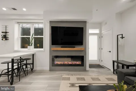 a living room with furniture a fireplace and a floor to ceiling window