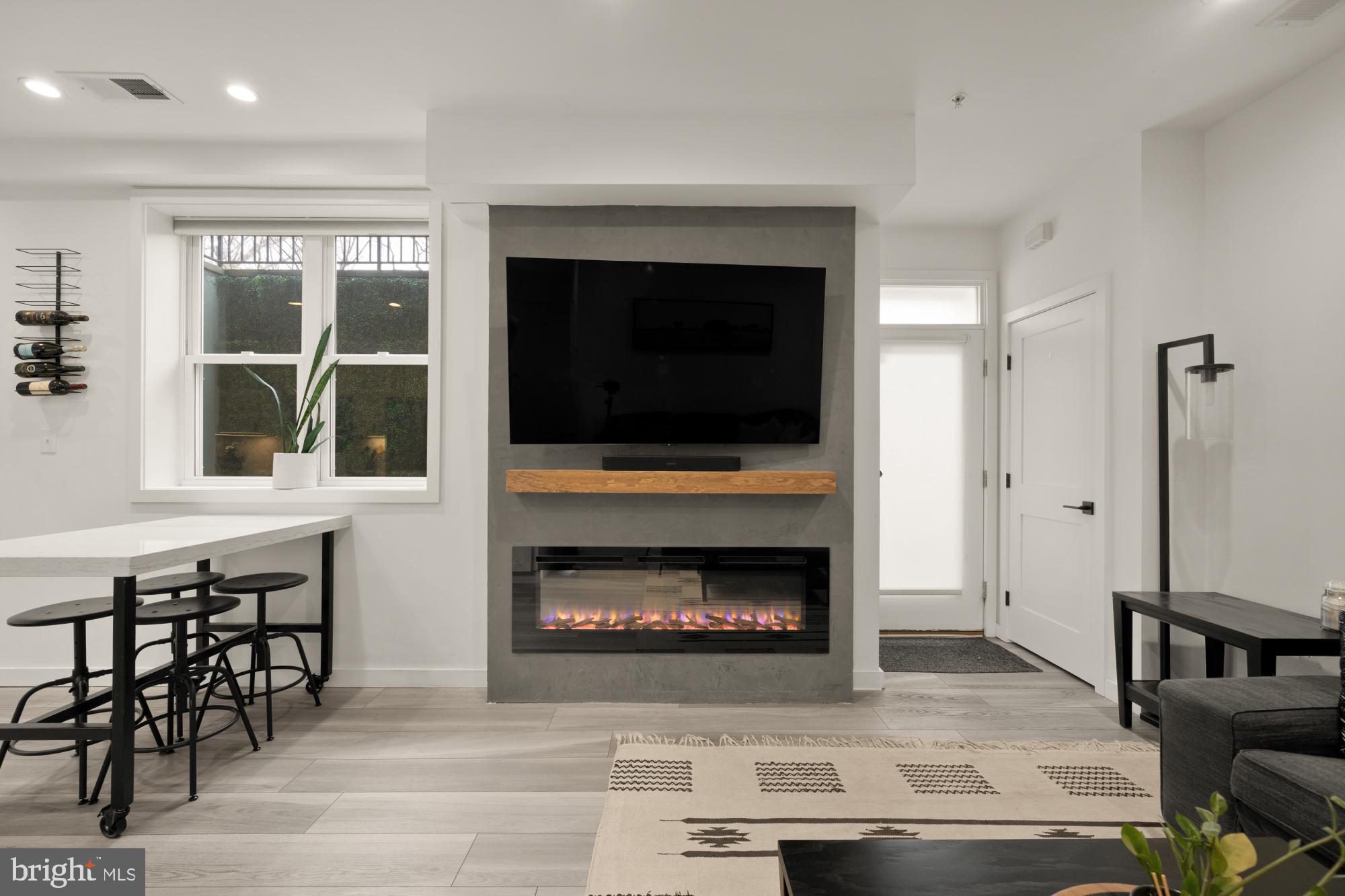 4816 3rd Street Northwest, Unit 2 Washington, DC 20011 - Photo 5 of 35 a living room with furniture a fireplace and a floor to ceiling window
