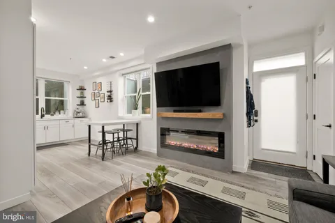 a living room with furniture a flat screen tv and a fireplace