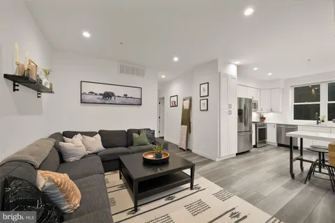 a living room with furniture and kitchen view