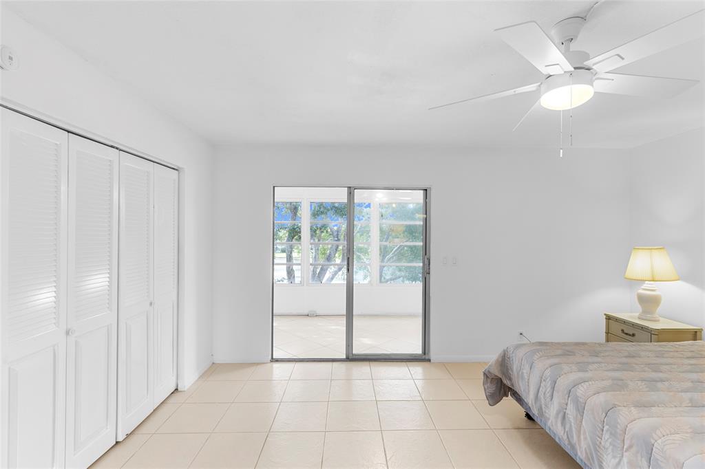 4047 Cambridge C, Unit 4047 Deerfield Beach, FL 33442 - Photo 12 of 43 a bedroom with a bed and a lamp