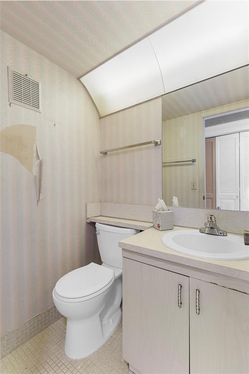 4047 Cambridge C, Unit 4047 Deerfield Beach, FL 33442 - Photo 20 of 43 a bathroom with a sink a toilet and vanity