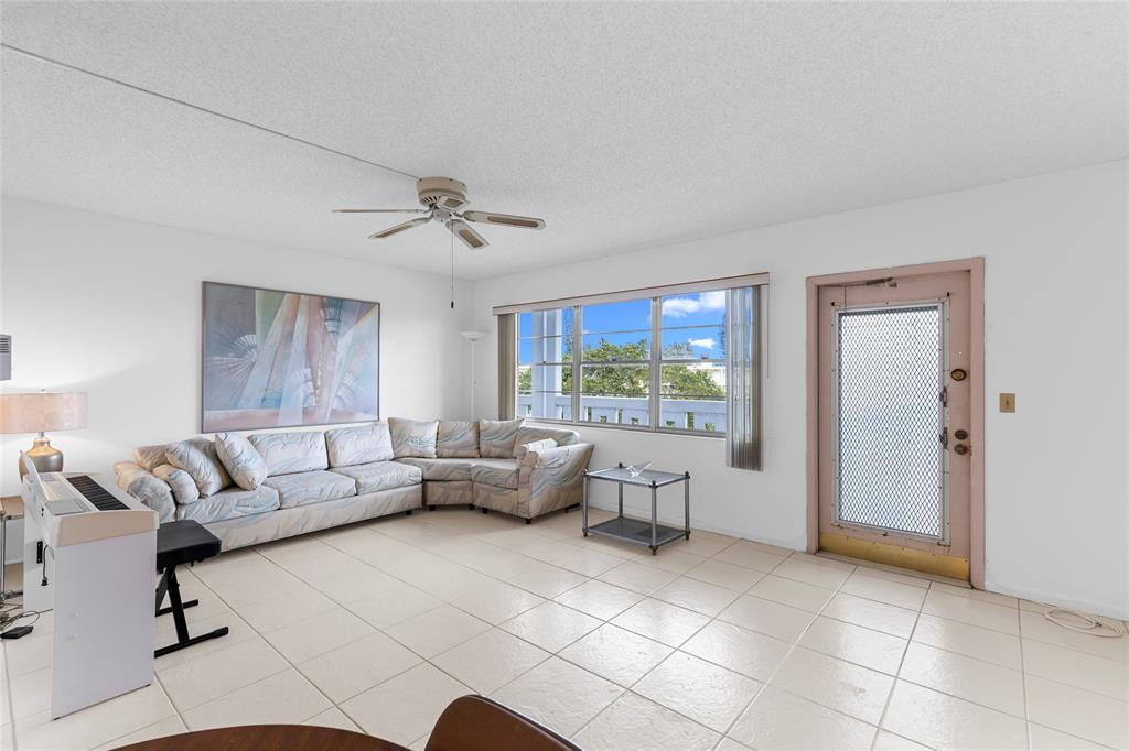 4047 Cambridge C, Unit 4047 Deerfield Beach, FL 33442 - Photo 2 of 43 a living room with furniture and a large window
