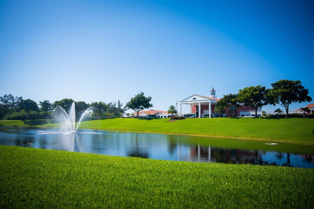 4047 Cambridge C, Unit 4047 Deerfield Beach, FL 33442 - Photo 28 of 43 a view of pool with lawn chairs and large trees