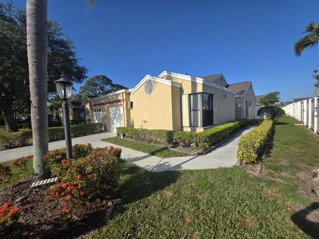 a view of a house with a big yard and potted plants