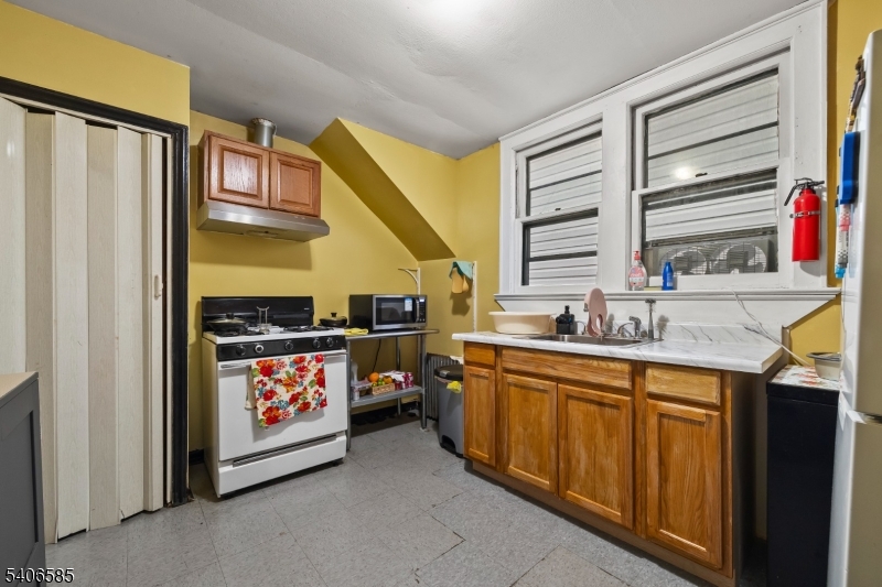 150 Jefferson Street Paterson, NJ 07522 - Photo 16 of 31 a kitchen with stainless steel appliances a stove and a refrigerator