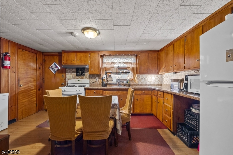 150 Jefferson Street Paterson, NJ 07522 - Photo 7 of 31 a kitchen with stainless steel appliances granite countertop a stove a refrigerator a sink dishwasher with a dining table and chairs with wooden floor