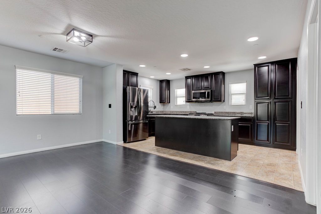 7724 Vibrant Thread Court Las Vegas, NV 89149 - Photo 43 of 43 An open floorplan seamlessly connects the living area to a modern kitchen, featuring sleek stainless steel appliances and abundant cabinetry.