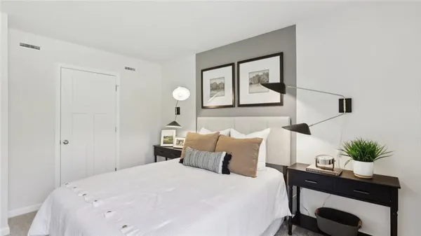 a bedroom with a bed and a potted plant