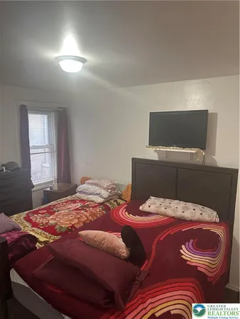 a bedroom with a bed and flat screen tv