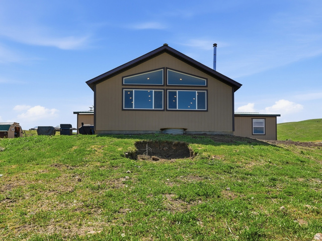 8066 North Valley View Heights Preston, ID 83263 - Photo 2 of 34 Modern dwelling featuring a sloped roofline, tan siding, and a prominent window array on the rear facade