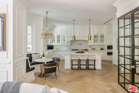 a view of kitchen with kitchen island stainless steel appliances refrigerator stove dining table and chairs